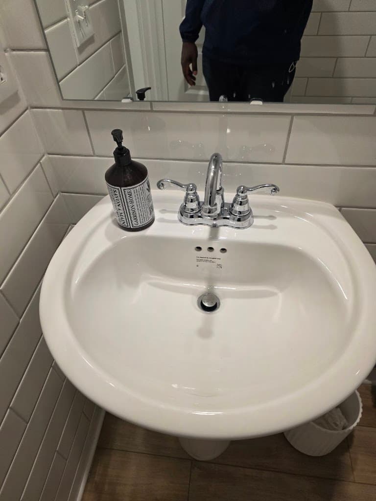 SAFCOM Clean Pro technician finishing a deep-cleaned bathroom sink