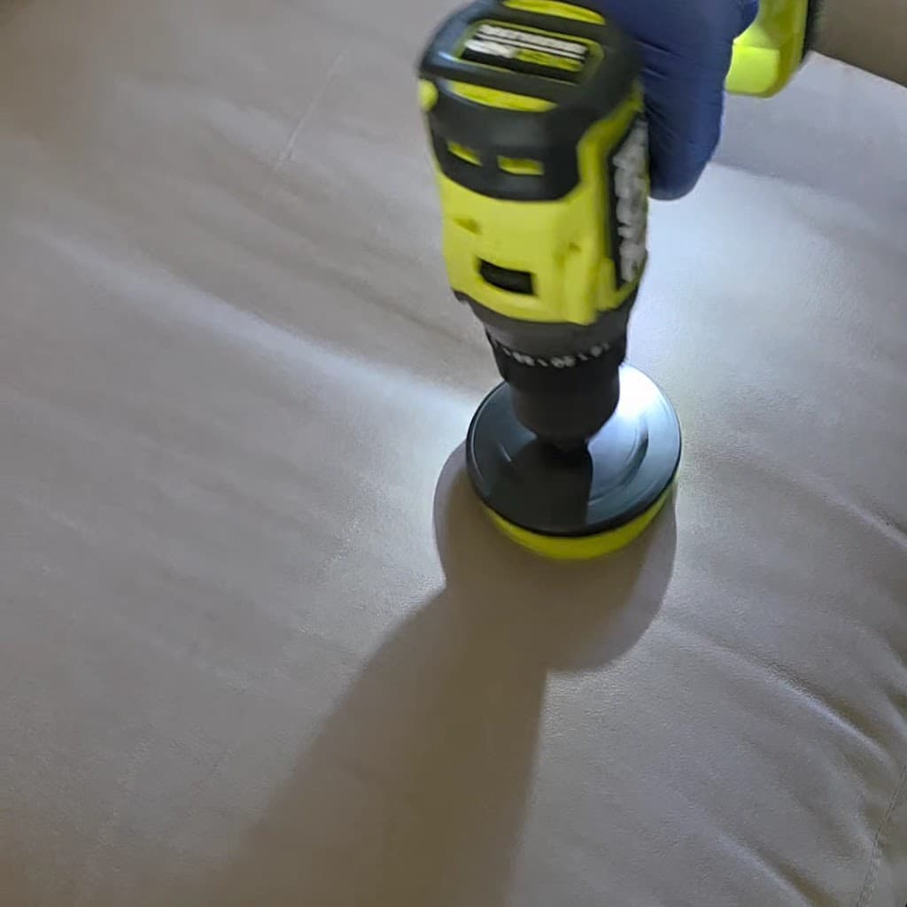Close-up of a rotary brush attachment cleaning a couch cushion